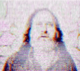 a blurry picture of jesus with long hair and a beard on a tv screen .