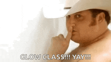 a shirtless man in a cowboy hat is holding his finger to his lips and saying `` glow class !!! yay !!! ''