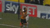 a soccer player is running on the field in front of a banner that says betting be