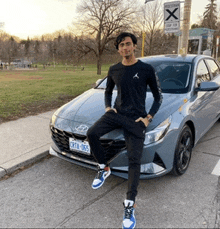 a man is kneeling on the front of a car with a license plate that says crt1-365