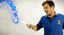 a man in a blue shirt is holding a light sword