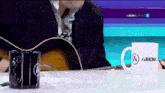 a man is playing a guitar in front of a cup that says arena on it