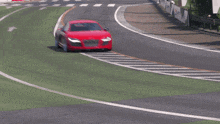 a red sports car is driving on a road