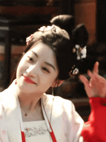 a woman wearing a red and white dress and a bun with a flower in her hair