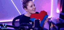 a woman holding a red heart in front of a microphone with the word vaporwave on the bottom right corner