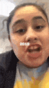 a close up of a girl 's face with the year 2019 on her face