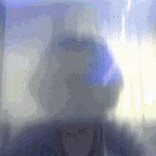 a blurred image of a person behind a purple curtain