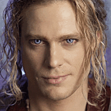 a close up of a man 's face with blue eyes and blonde hair
