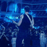a man is playing a guitar in front of a crowd of people