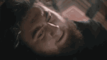 a man with a beard is laying on his back with his head on the floor