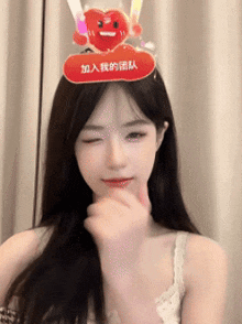 a woman wearing a headband with a heart and chinese writing on it