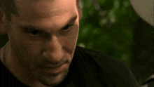 a close up of a man 's face in a black shirt