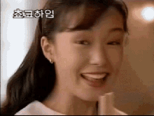 a close up of a woman 's face with her mouth open and a foreign language on the bottom .