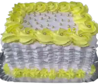 a white cake with yellow frosting and pearls says a.c