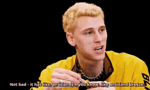 a man in a yellow shirt is smoking a cigarette and saying not bad
