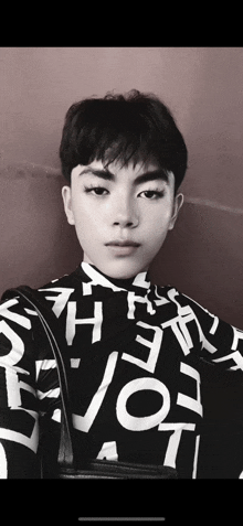 a black and white photo of a young man wearing a shirt that says devotion on it
