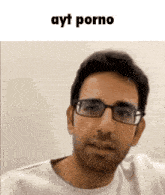 a man wearing glasses and a white shirt is looking at the camera with the words ayt porno above him .