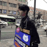 a man is walking down the street with a sign that says ' t x ' on it