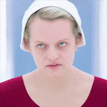 a woman wearing a red shirt and a white towel on her head