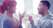 a man and a woman are holding wine glasses and drinking from them .