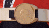 a close up of a gold belt with the time 7:32