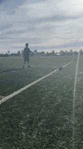 a boy is kicking a soccer ball in a field