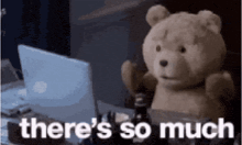 a teddy bear is sitting in front of a laptop with the words there 's so much written below it .