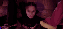 a woman sitting on a couch with a black sweatshirt that says ' i love you ' on the front