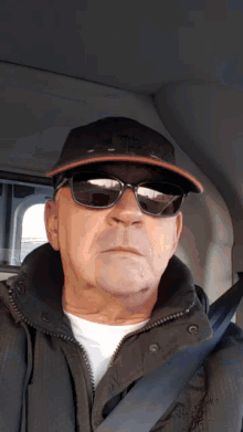a man wearing sunglasses and a hat with the letter a on it