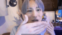 a close up of a person 's face with their hands covering their mouth