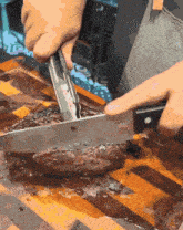 a person is cutting a steak with tongs and a knife