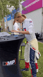 a woman in a tommy hilfiger outfit stands in front of a table