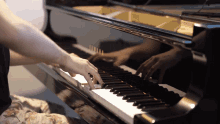 a person playing a piano with a reflection of their hands