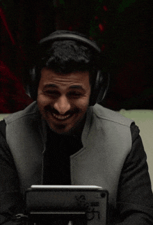 a man wearing headphones is clapping his hands in front of his face