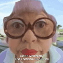 an elderly woman wearing glasses and red lipstick says " good morning just looking in on you "