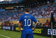 a soccer player wears a blue jersey with the number 10 on it