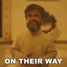 a man with a beard is standing in front of a sign that says " on their way "
