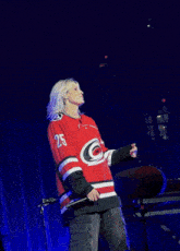 a woman wearing a red and black jersey with the number 5 on it