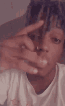 a close up of a person making a peace sign with their hands .