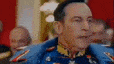 a man in a military uniform is standing in front of a crowd of people .