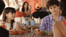 a boy and a girl are sitting at a table with bowls of food on it