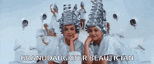 a group of women are standing next to each other in a room with the words `` granddaughter beautician '' written on the screen .
