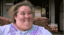 a woman is sitting in a chair with her mouth open and smiling .