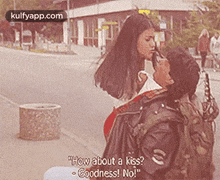 a woman is kissing a man on the cheek while sitting on a bench .