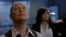 a man in a striped shirt is looking up at something