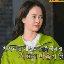 a woman is wearing a green jacket with chinese writing on it