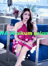 a woman in a pink dress is sitting on a blue couch with wa alaikum salam written in green