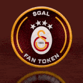 a red and gold coin with the word sgal on the top