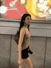 a woman is walking in front of a wall with a sign that says celi court on it