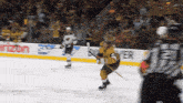 a hockey player stands on the ice in front of a verizon advertisement